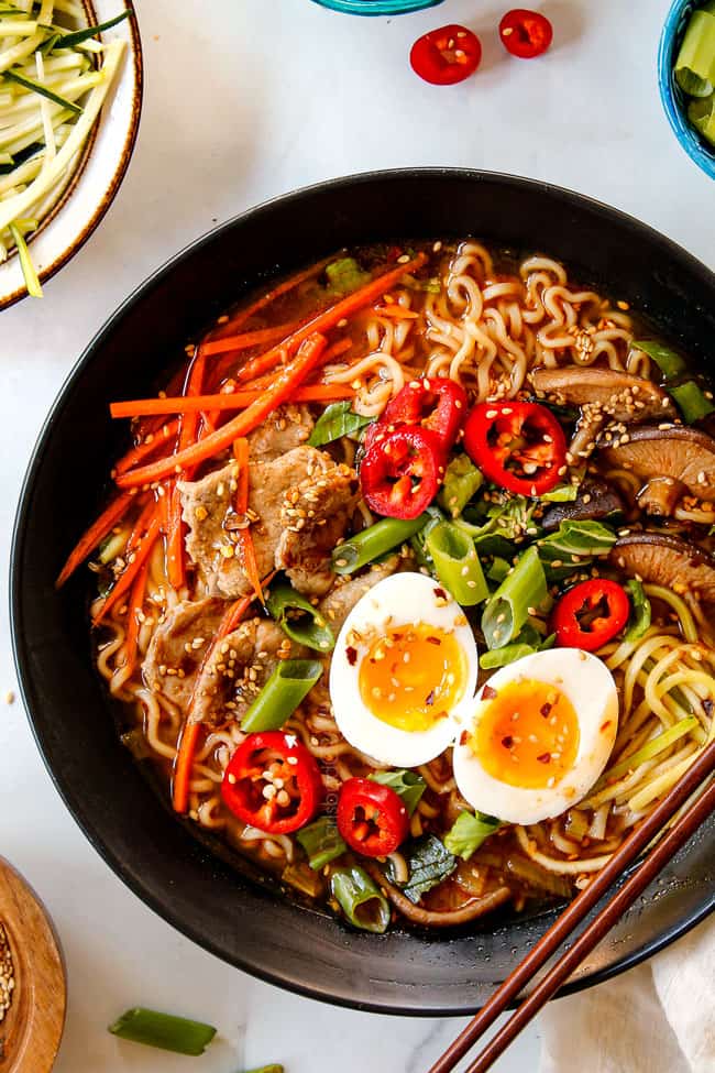 showing how to make ramen recipe by topping with sesame seeds, Ramen eggs, bok choy