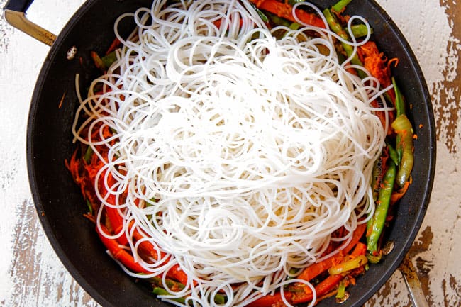 showing how to make Singapore Rice Noodles by adding the cooked rice vermicelli