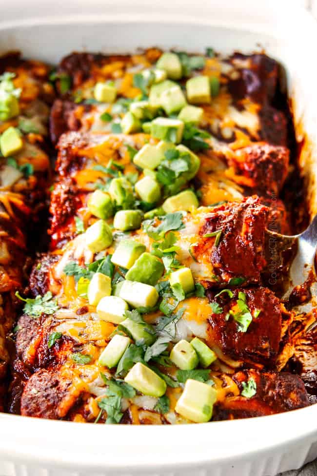 a spatula picking up one chicken enchilada