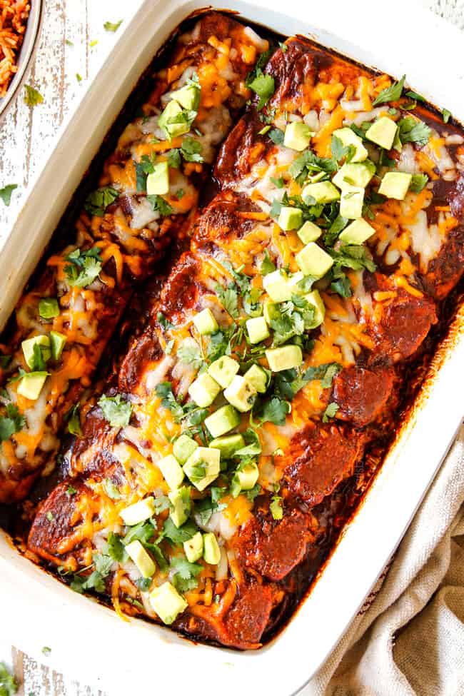 top view of red chicken enchilada recipe garnished with avocados and cilantro