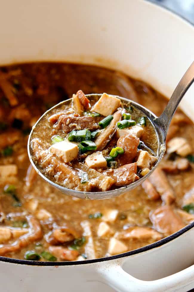 showing how to serve Hot and Sour Soup recipe by garnishing with green onions