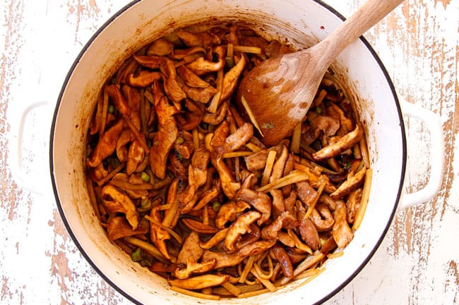 showing how to make hot and sour soup recipe by cooking pork, mushrooms and water chestnuts together in a Dutch oven along with soy sauce, garlic and ginger