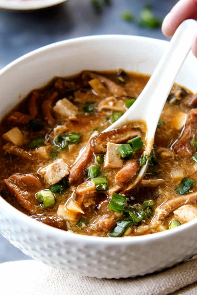 up close of eating Hot and Sour Soup by scooping up a big spoonful