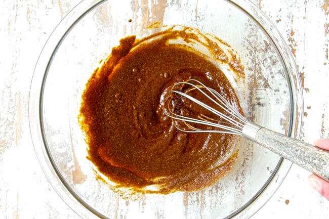 showing to make chicken shawarma by whisking spices together with lemon juice and olive oil to marinate chicken