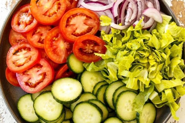 showing to make shawarma by chopping tomatoes, lettuce, red onions and cucumbers