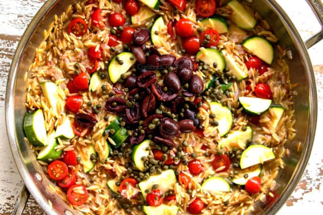 showing how to make Lemon Garlic Shrimp by adding olives