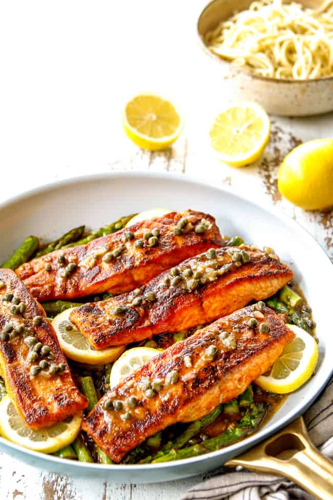 showing how to serve salmon and asparagus by serving in a pan over lemon slices