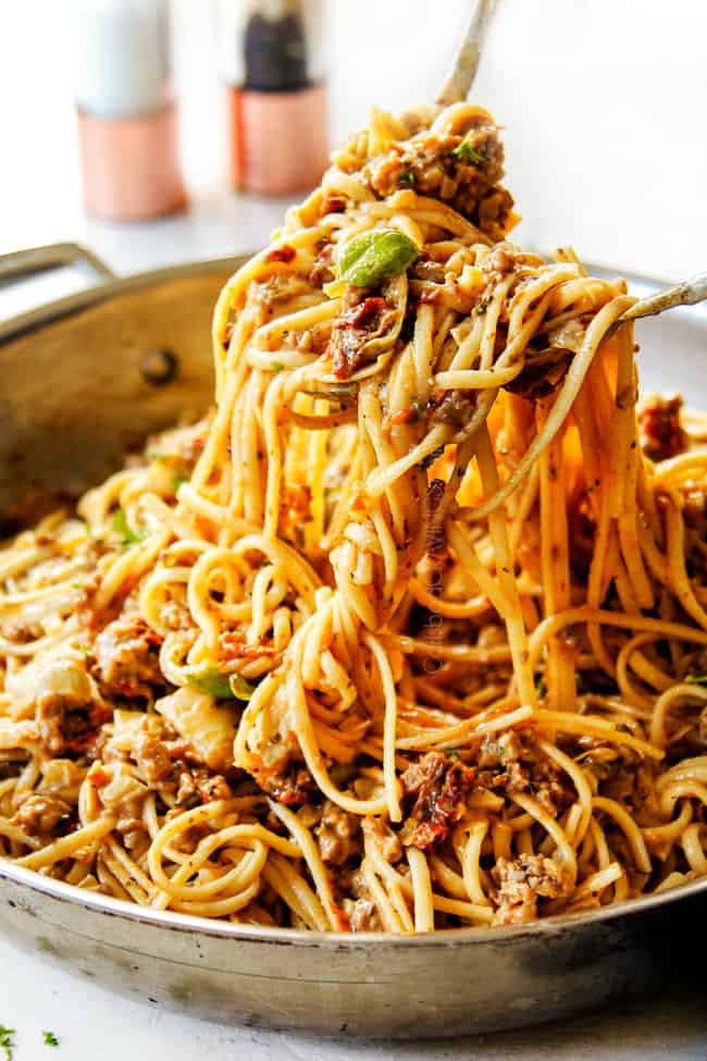 showing how to serve linguine pasta by two tongs picking up pasta