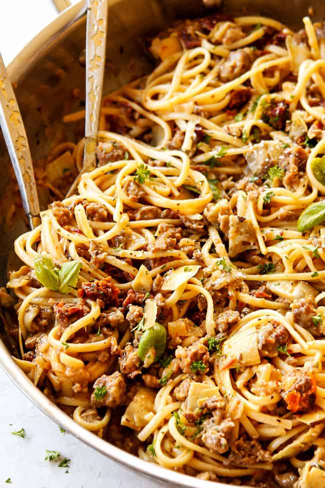 up close side showing how to serve linguine noodles by scooping up in tongs