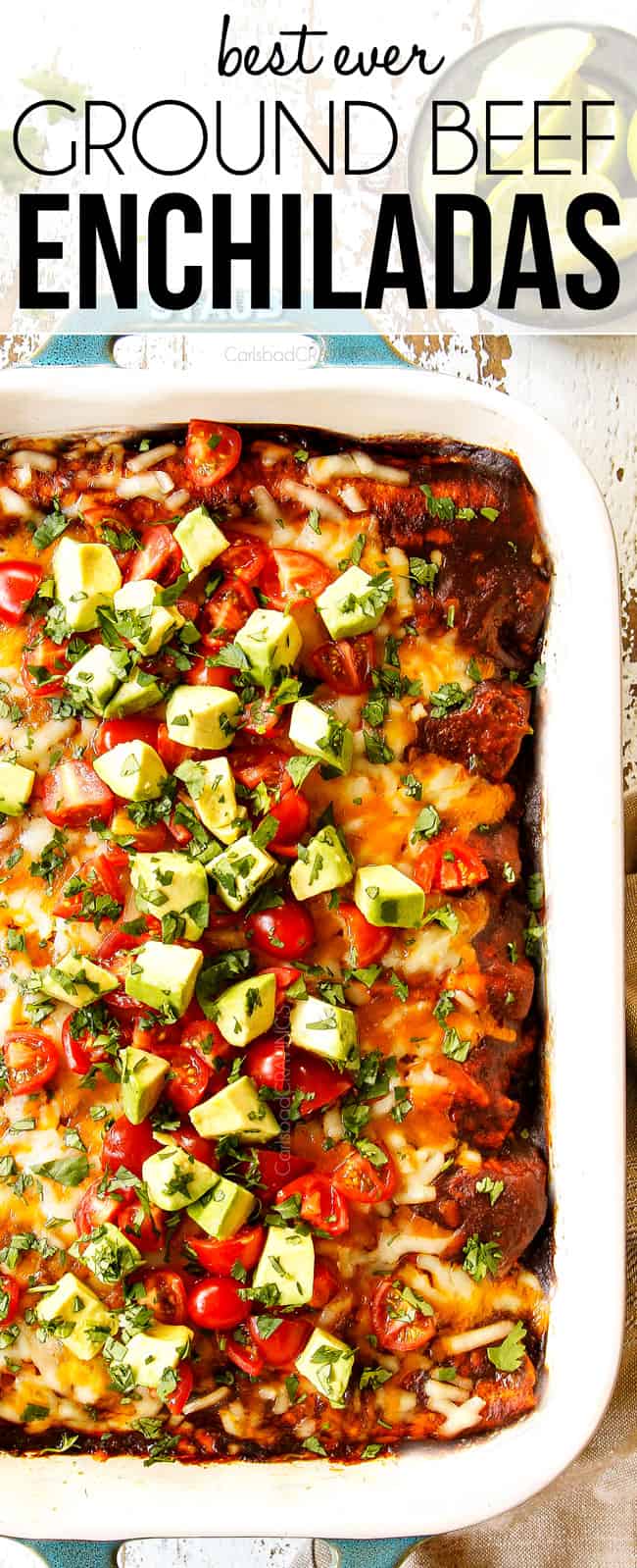 top view of beef enchilada recipe in a teal 9x13 pan showing how to garnish by topping with tomatoes, avocados and cilantro