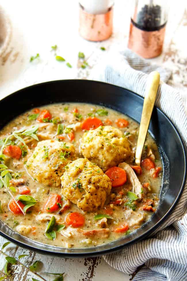 showing how to garnish best chicken and dumplings recipe by topping with parsley and fresh oregano