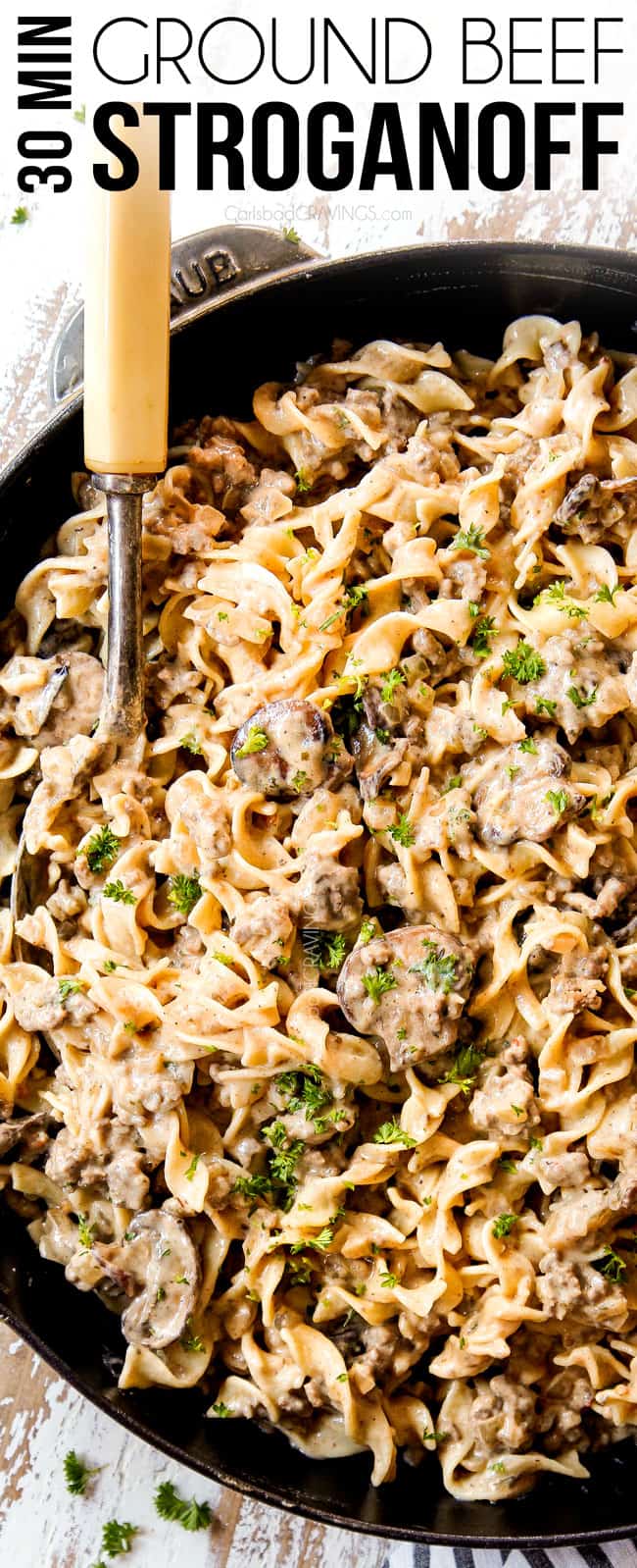 top view showing how to make ground beef stroganoff recipe by adding noodles to sauce in a skillet