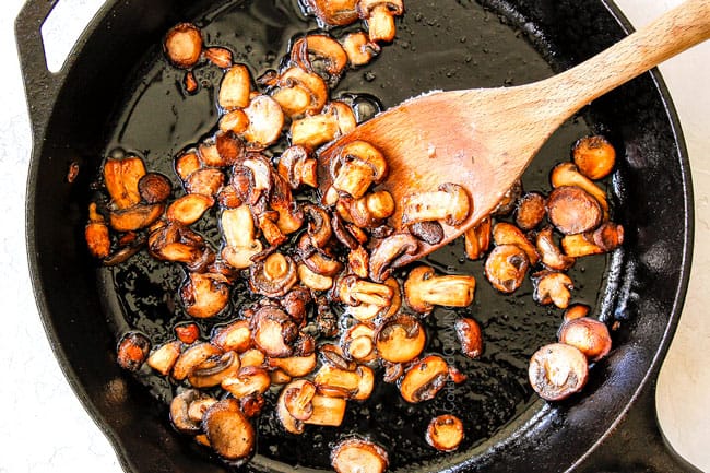 showing how to make mushroom risotto recipe by caramelizing onions with butter in a cast iron skillet