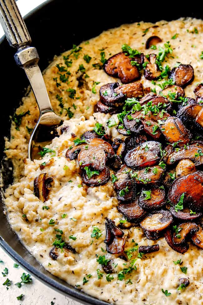 side view of of a spoon serving easy mushroom risotto recipe to show the correct creamy consistency