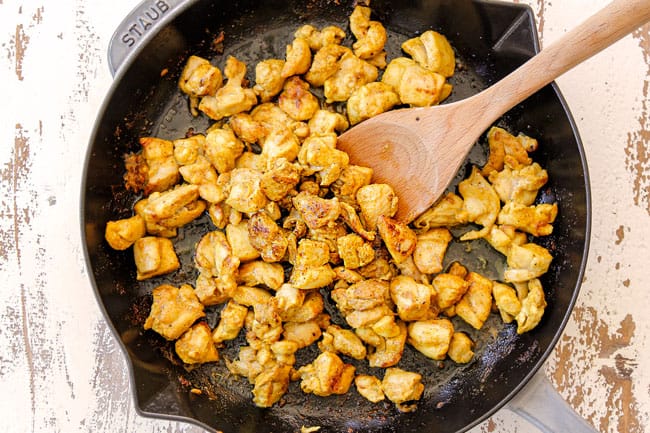 showing how to make peanut butter chicken by browning chicken tossed in seasonings in a skillet