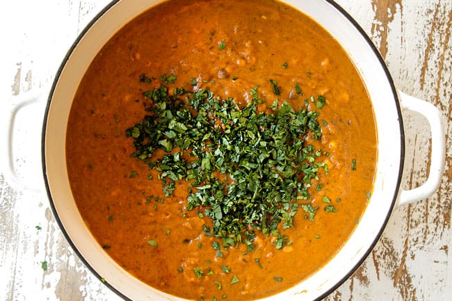 showing how to make creamy Chicken Enchilada Soup by stirring in cilantro