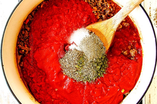 showing how to make best Baked Ziti by adding crushed tomatoes, tomato sauce, basil, parsley, thyme, garlic and red peppr