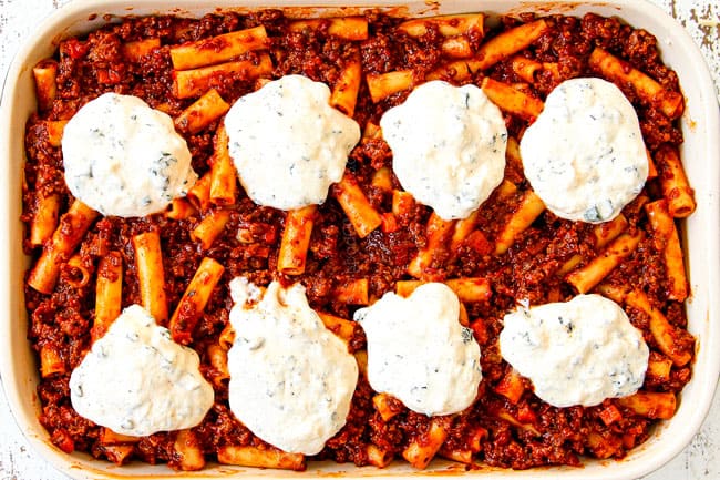 showing how to make best Baked Ziti with ricotta, Italian sausage and meat by topping with remaining ziti pasta and remaining ricotta