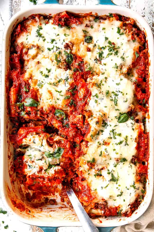 showing how to to garnish Baked Ziti with ricotta and sausage with a top view of the pan adding basil and parsley