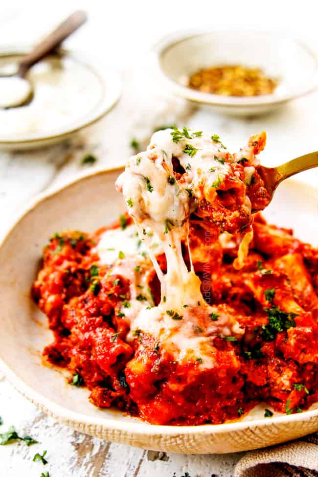 showing how cheesy Baked Ziti recipe is with a pull shot of a forkful of ziti pasta