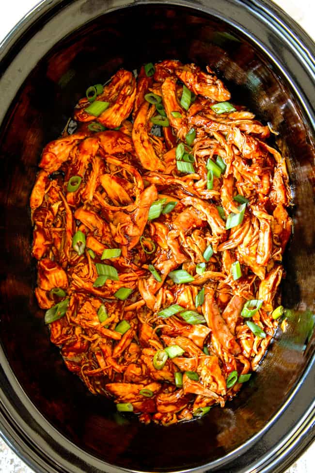 showing how to make slow cooker honey garlic chicken by shredding chicken in the crockpot