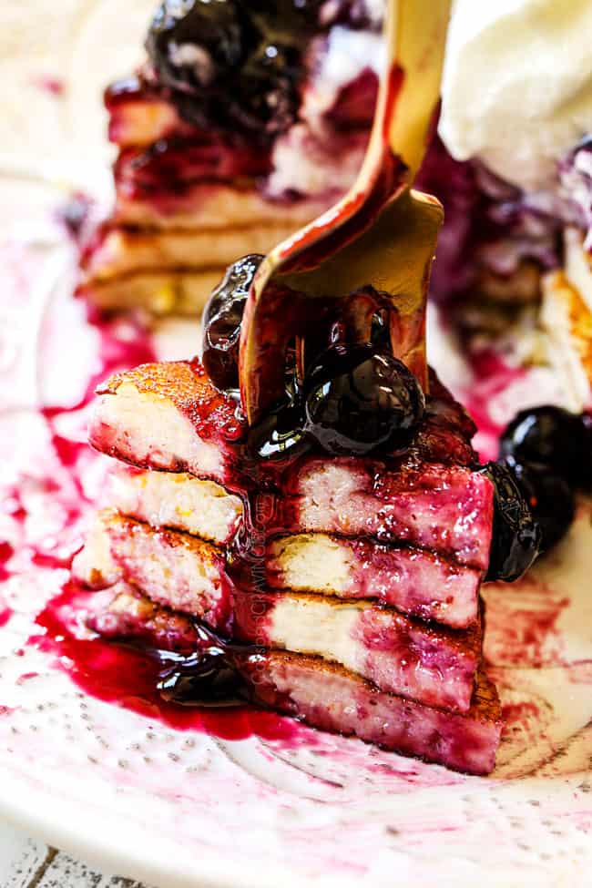 showing how to eat lemon ricotta pancakes with an up close of a forkful of layers of pancakes