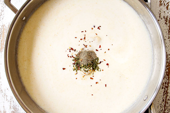 showing how to make mac and cheese by seasoning with bouillon, parsley, salt, pepper and red pepper flakes