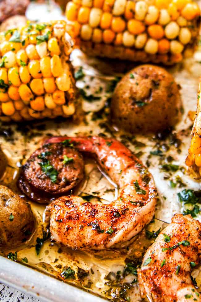 up close of shrimp boil recipe showing shrimp drenched in lemon juice and garnished with parsley