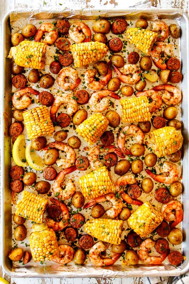 showing how to make shrimp boil recipe by baking shrimp, corn, sausage and potatoes on a sheet pan until cooked through