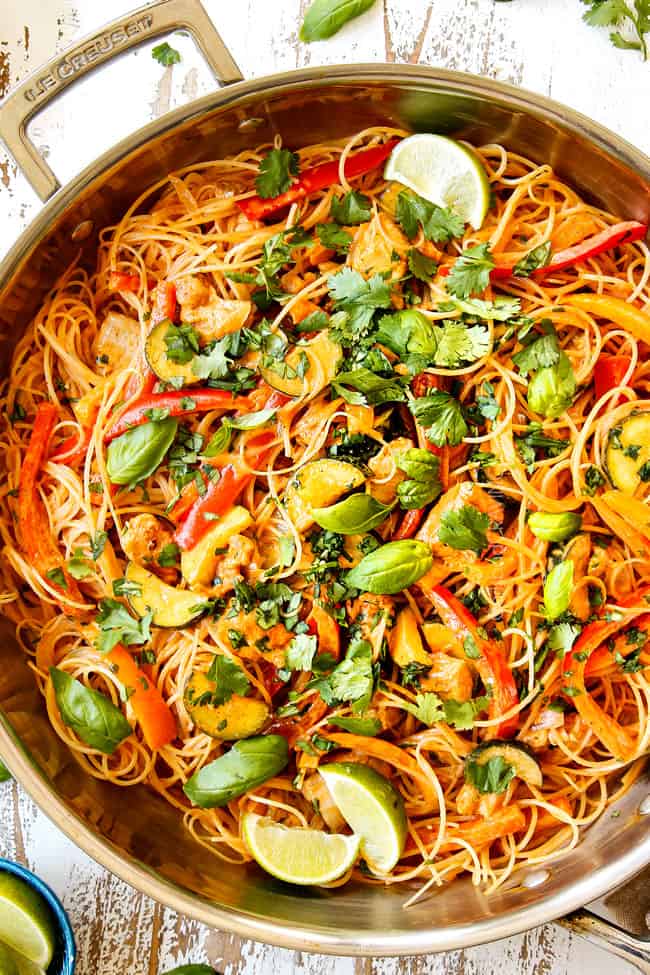 top view of rice noodles recipe in a skillet showing how to garnish with cilantro and lime juice