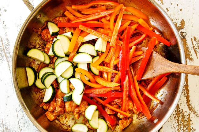 showing how to make rice noodles recipe by stir frying bell peppers and zucchini