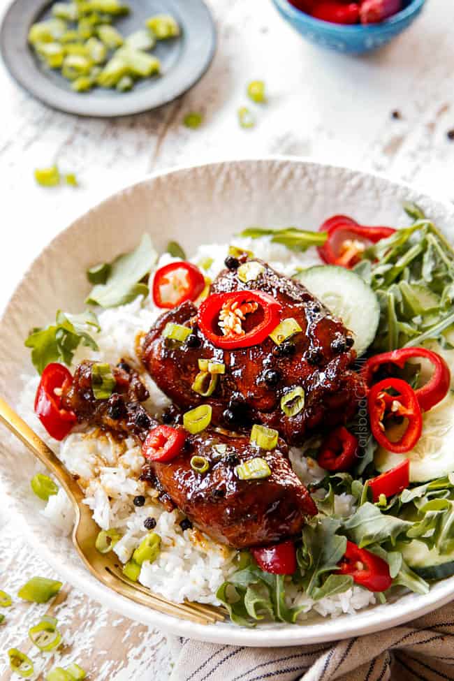 showing how serve Filipino Chicken Adobo by adding to white rice in a bowl with green salad
