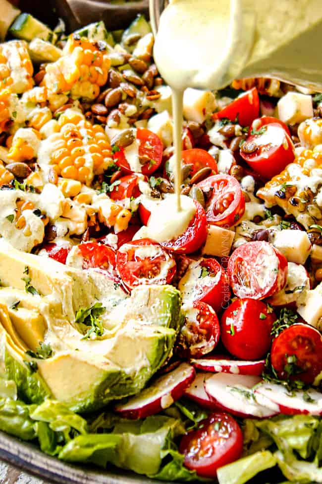 up close of pouring cilantro lime dressing over Mexican Salad