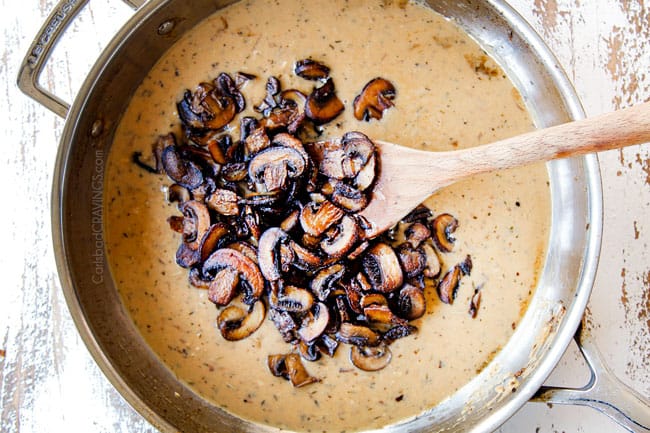 showing how to make mushroom pasta by adding mushrooms to creamy sauce in stainless steel skillet
