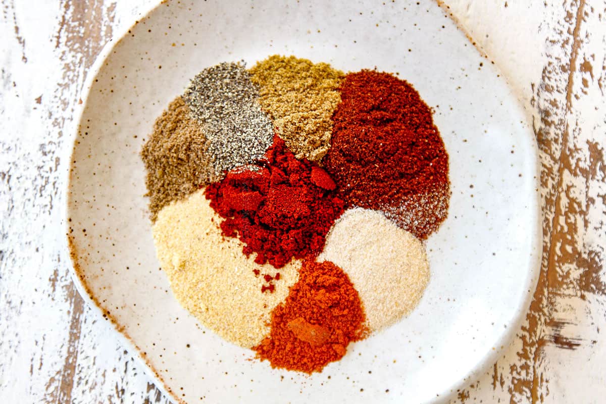 showing how to make carne asada recipe by gathering seasonings: chili powder, garlic powder, onion powder, coriander, cayenne pepper, salt