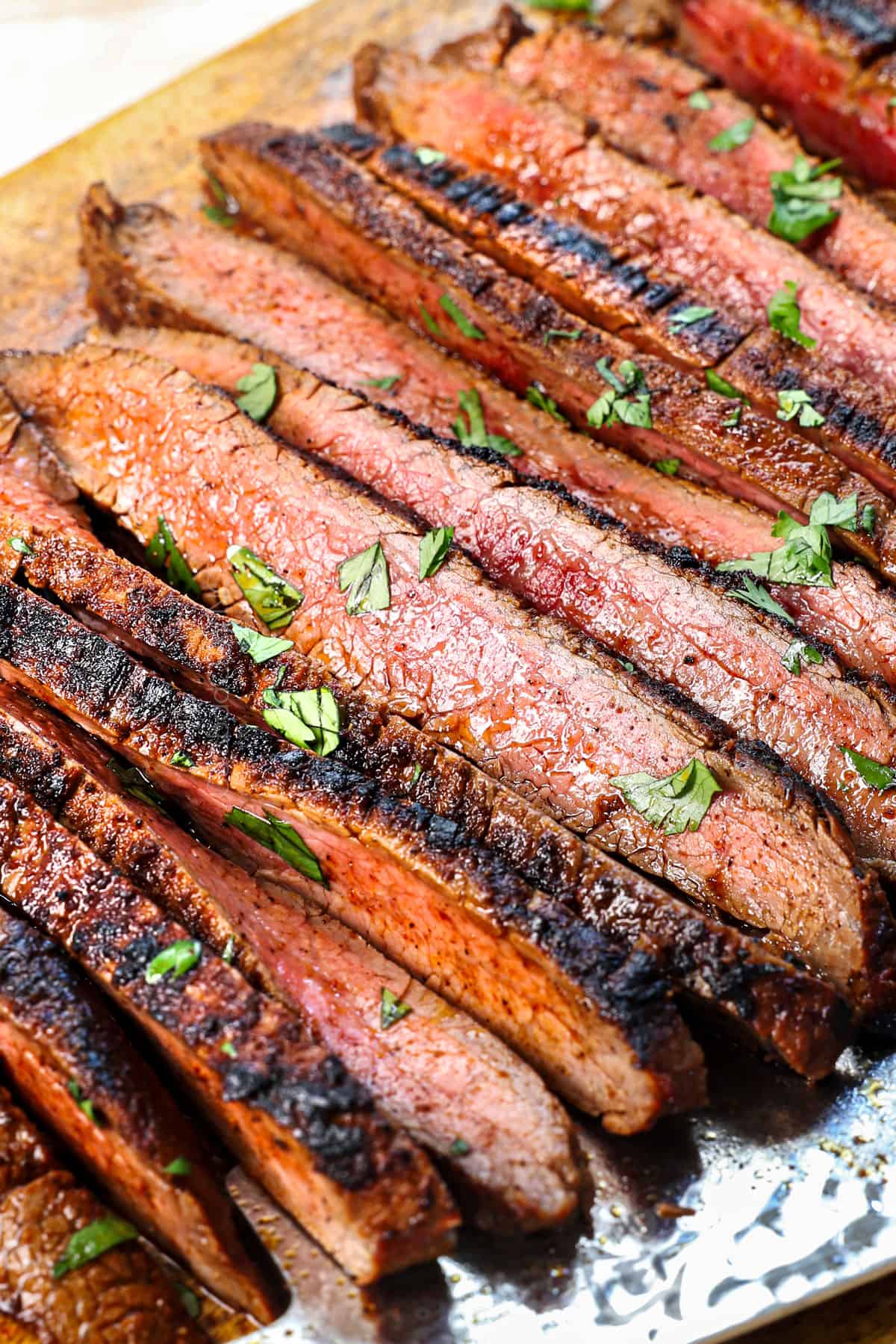 up close of carne asada meat sliced on a cutting board showing what medium-rare looks like