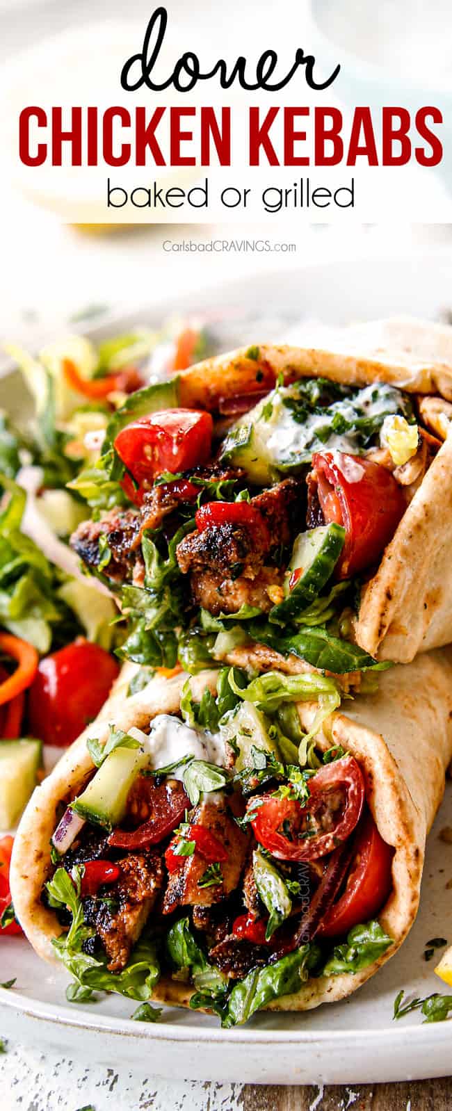 up close of doner kebab with chicken, hummus, tomatoes, red onions, cucumber and yogurt sauce
