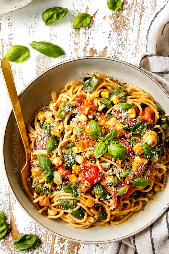 top view of a grey bowl of spinach pasta recipe garnished with Parmesan