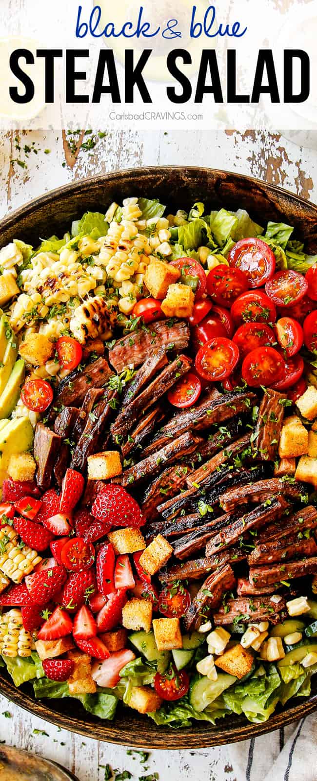 top view of grilled steak salad with grilled corn,tomatoes and avocado in a wooden bowl