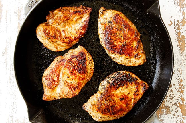 showing how to make Tuscan Chicken recipe by searing breasts in a cast iron skillet