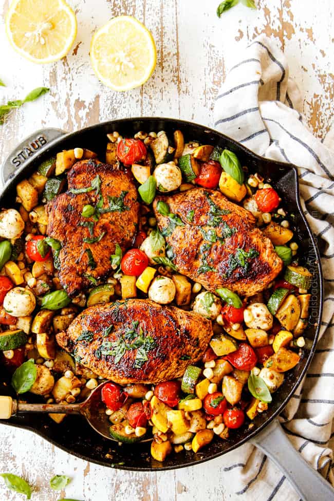 top view of Tuscan Chicken recipe with a big spoonful of veggies and chicken in a cast iron skillet