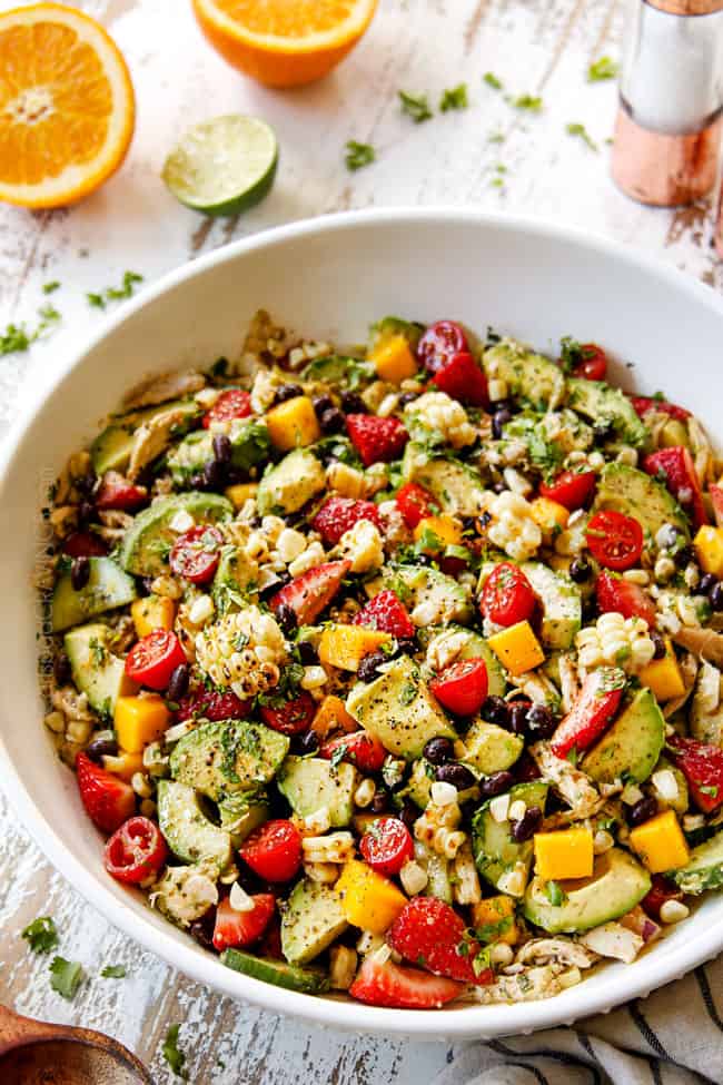 side view of avocado chicken salad with rotisserie chicken, chopped
avocados, corn, black beans and tomatoes in a white bowl