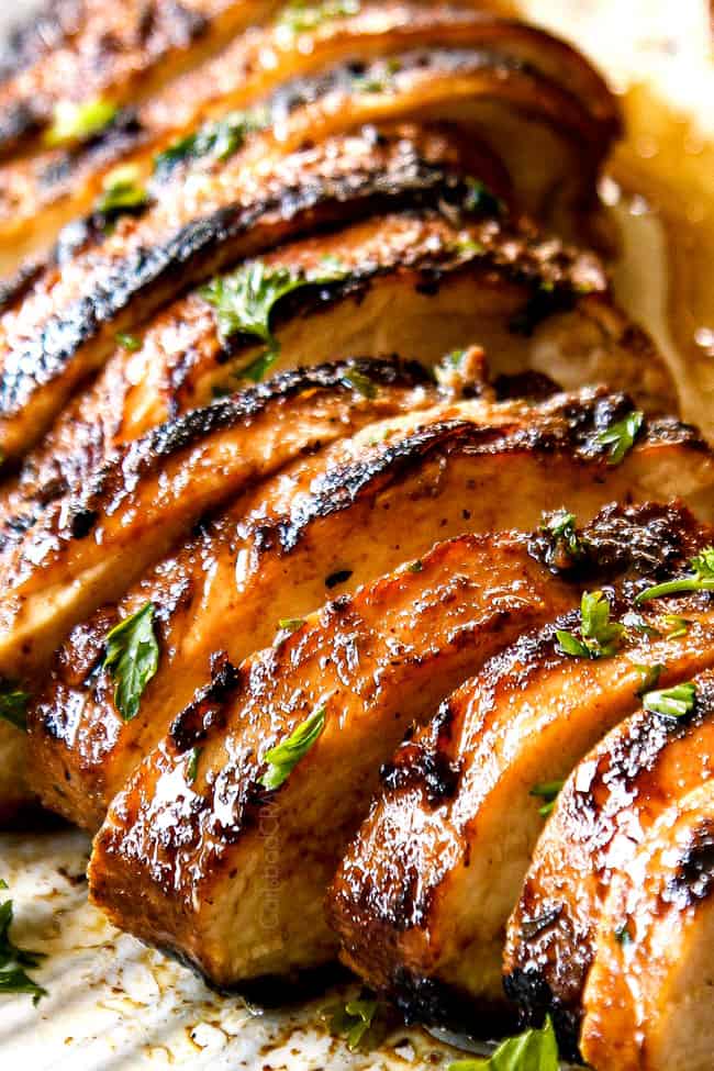 up close of marinated balsamic chicken breasts sliced on a white plate