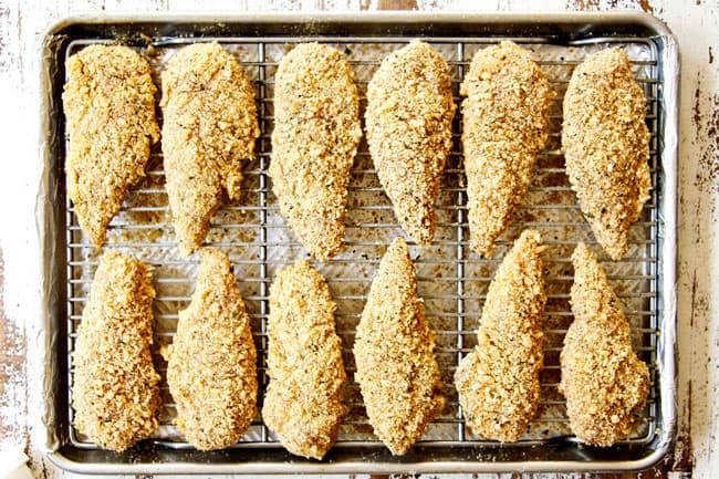 showing how to make Parmesan crusted chicken recipe by lining chicken in single layer on a baking sheet
