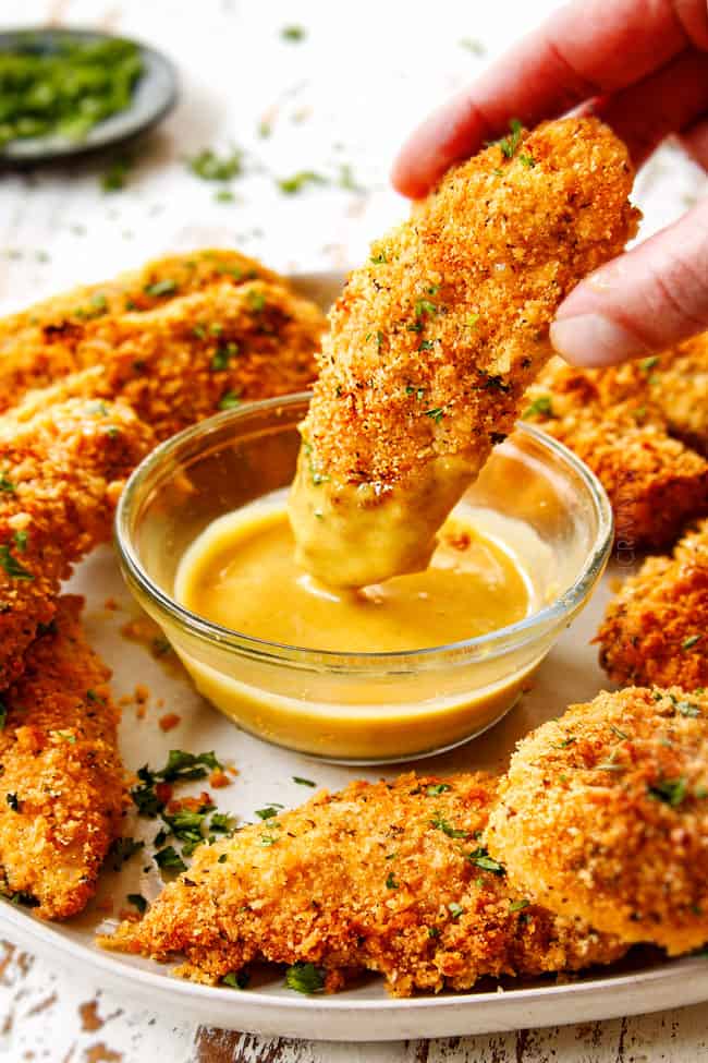 showing how to serve Parmesan crusted chicken recipe by dipping into honey mustard sauce