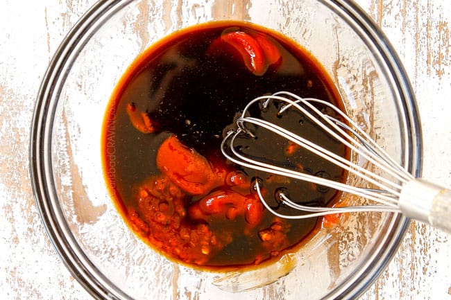 showing how to make yakisoba sauce by whisking Worcestershire, ketchup, soy sauce, oyster sauce, brown sugar and Asian chili sauce together in a glass bowl