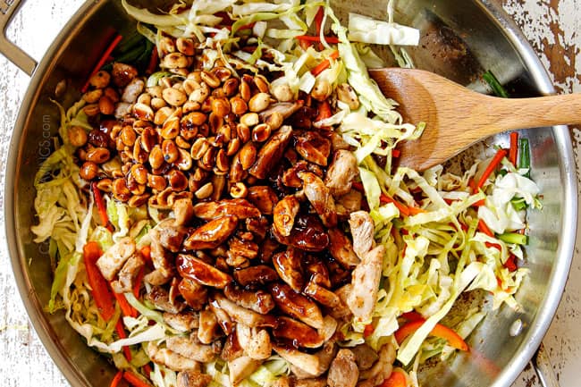 showing how to make yakisoba recipe by adding sauce and chicken back to the stainless steel skillet