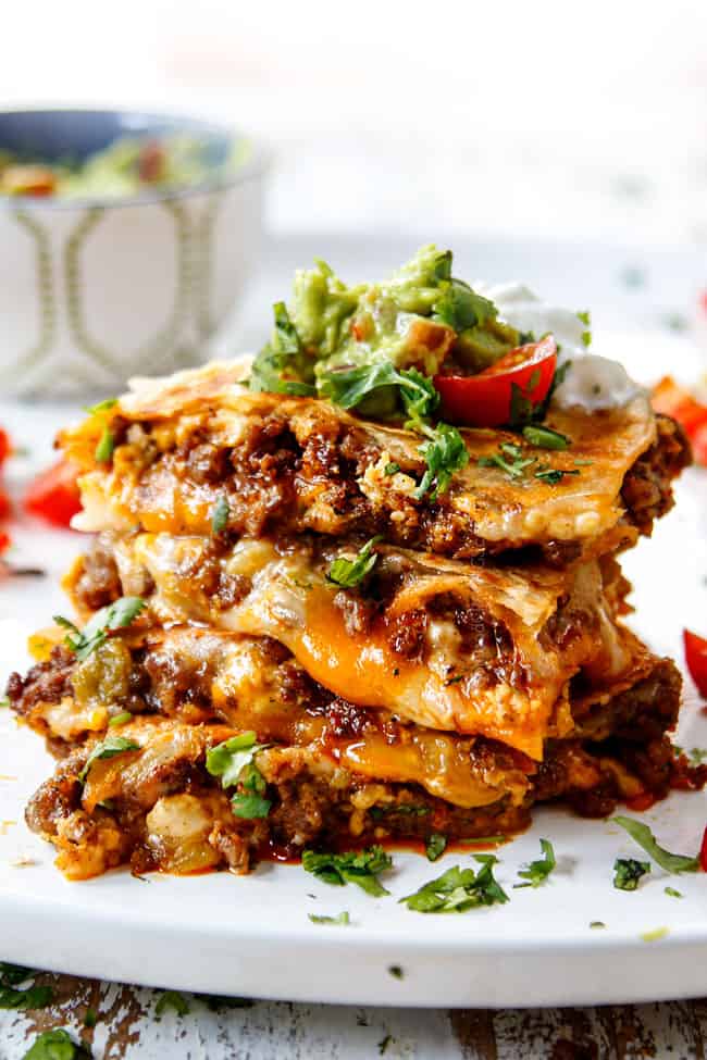 breakfast quesadillas stacked on top of each other with sour cream and guacamole