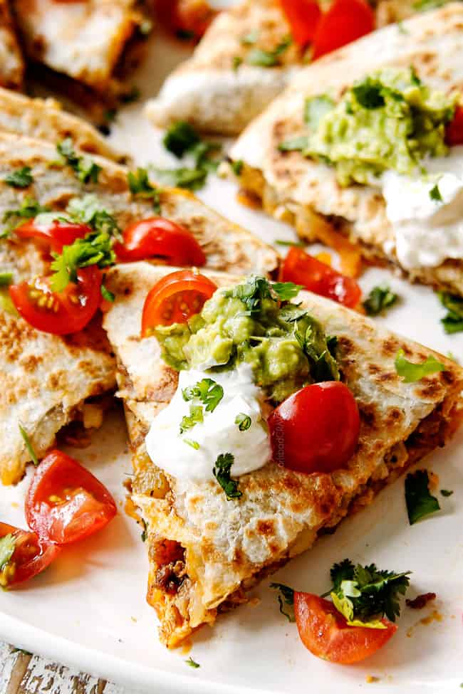 up close of crispy breakfast quesadilla garnished with sour cream or guacamole