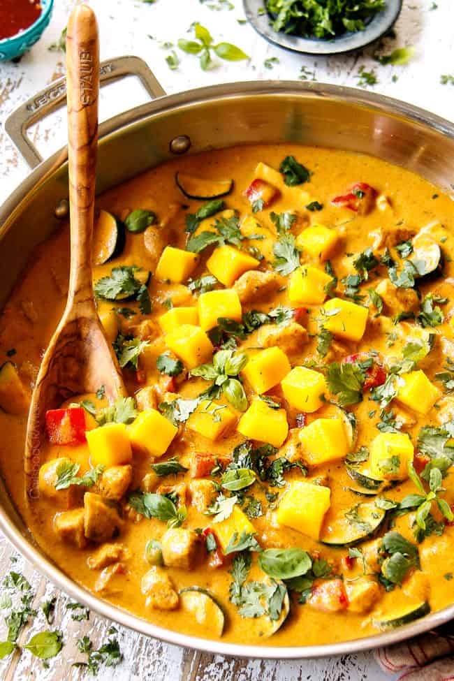 mango chicken in a stainless steel skillet with chicken, bell peppers, zucchini and fresh mangos